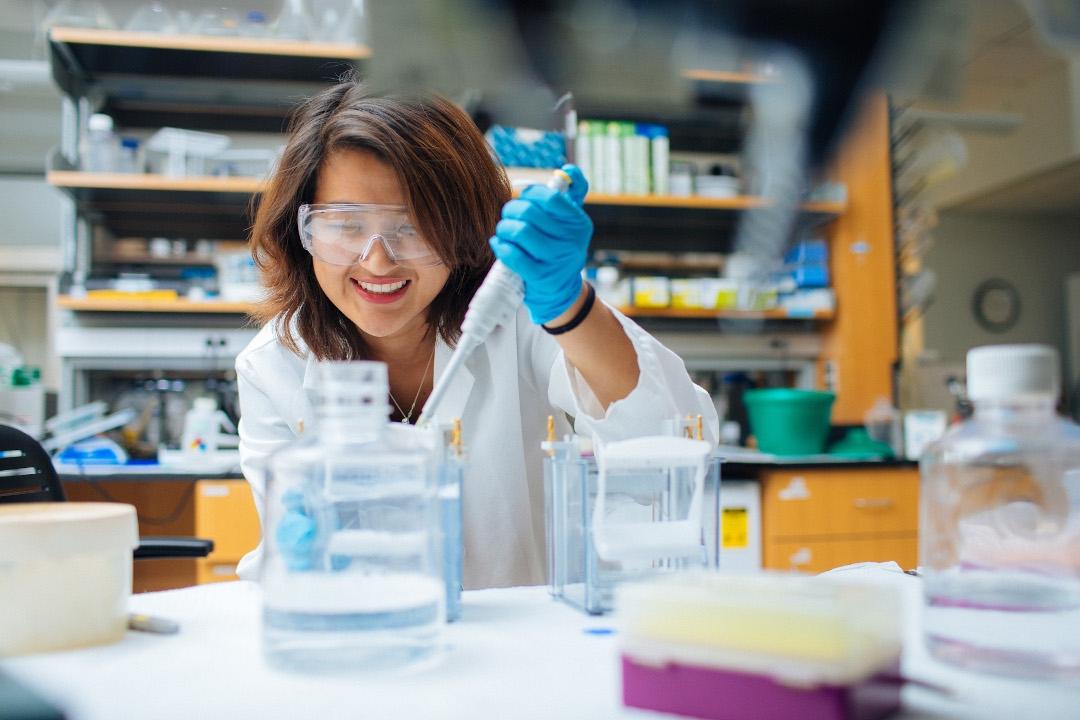 Liezelle Lopez in a lab coat in the chemistry lab 