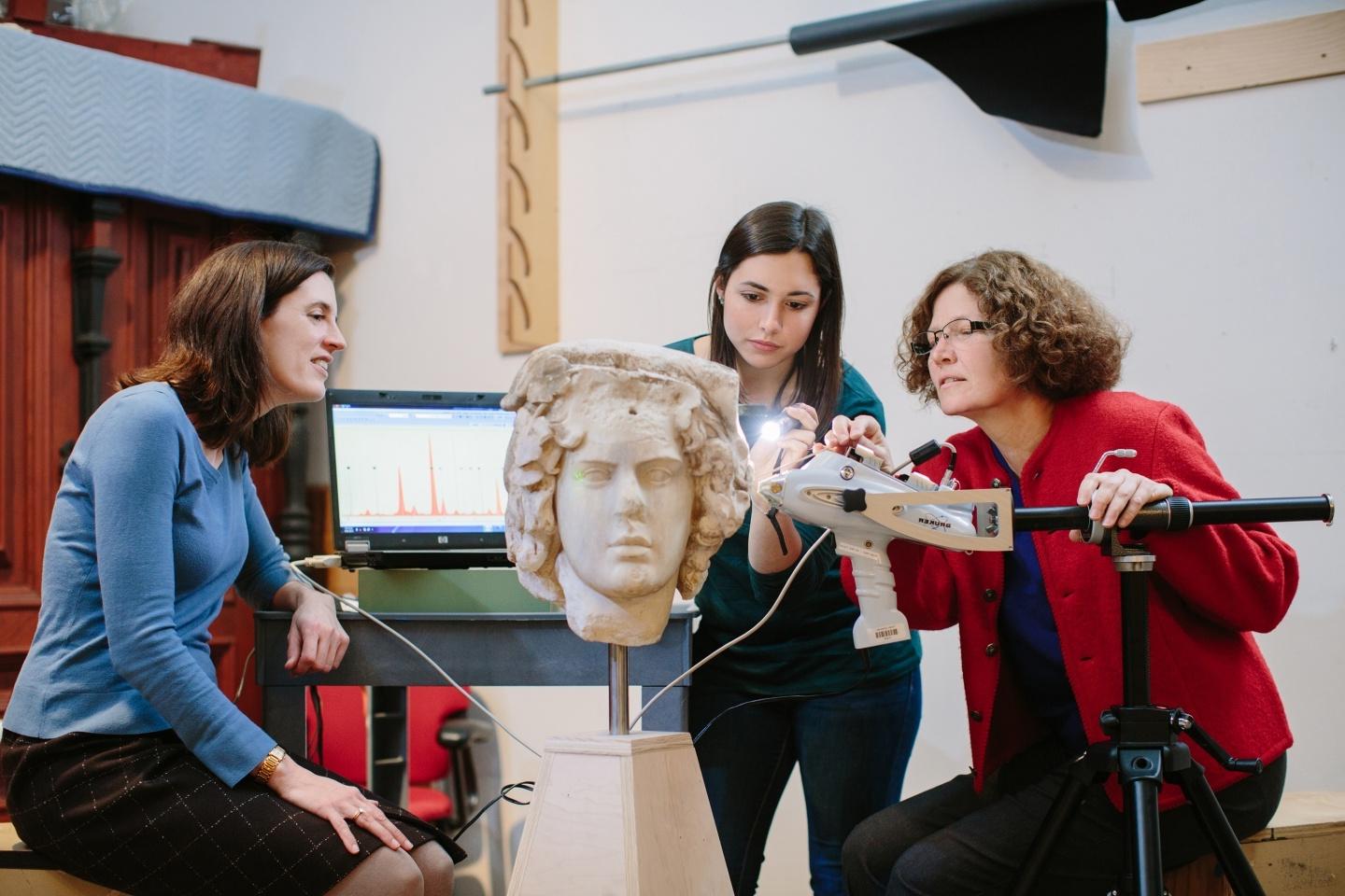 Professor and students looking at Greek sculpture